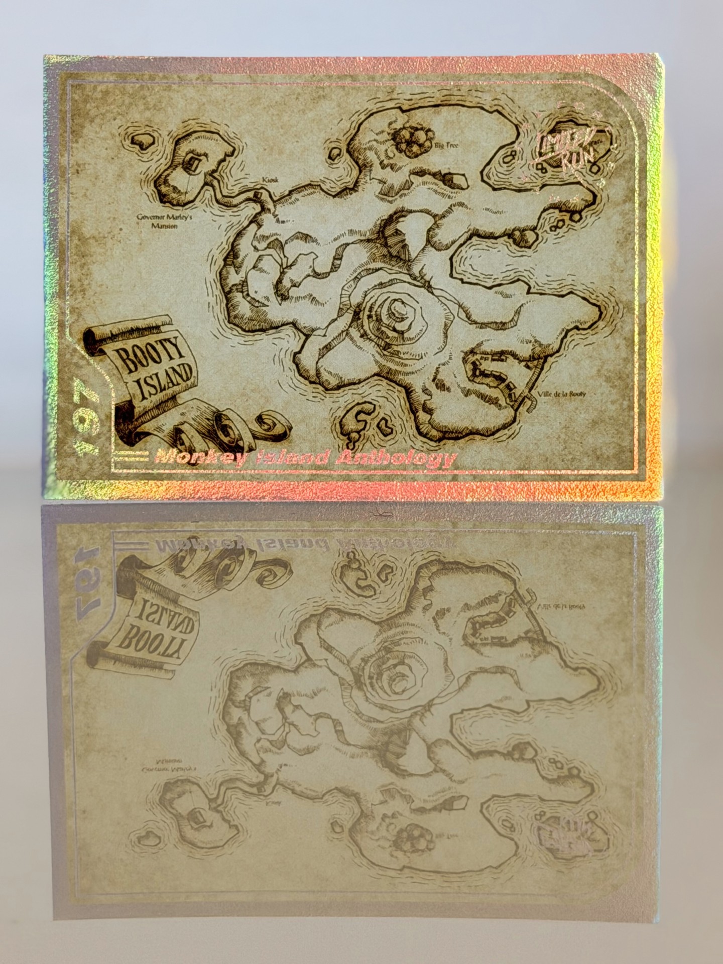 Booty Island da collezionare: carta con la mappa dell’isola, bordo iridescente e scritta Monkey Island Anthology, dalla raccolta di Alfnet. Un’isola da osservare anche lontano dallo schermo.
