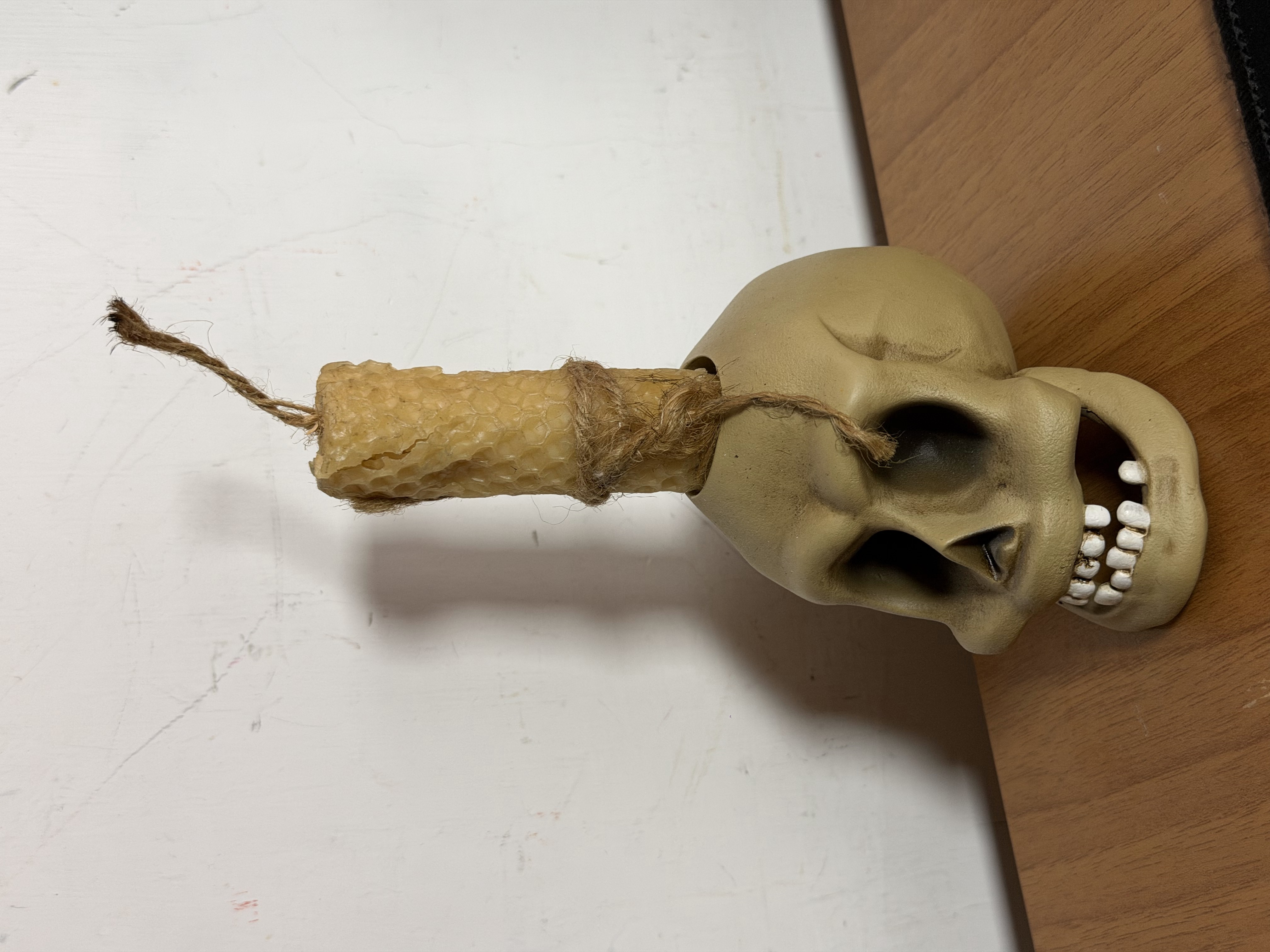 Un teschio decorativo con una candela e uno spago.